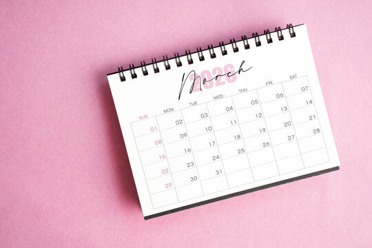 Top view of March 2026 desk calendar on pink pastel background. - Powered by Adobe