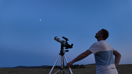 Amateur astronomer using telescope for watching stars, Moon, planets and other celestial objects...
