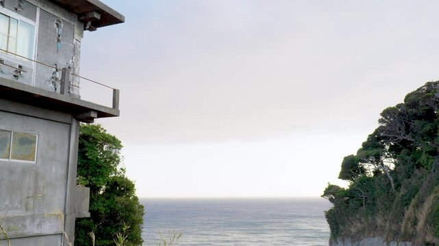 崖の上にある家、海、木々のある風景