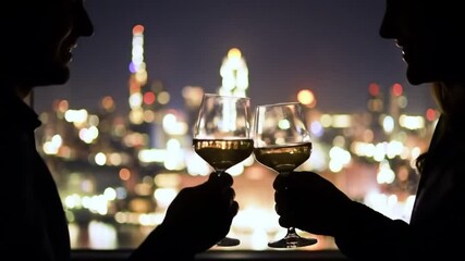 Romantic spouses silhouettes celebrating anniversary watching night lights city window closeup. Back view man woman toasting glasses at panoramic room. Beautiful lovers enjoying evening time together - Powered by Adobe