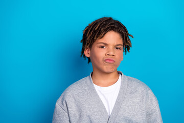 Confident young student making an expression in casual attire against blue background