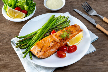 Grilled Salmon with Asparagus, Tomatoes and Lemon on White Plate