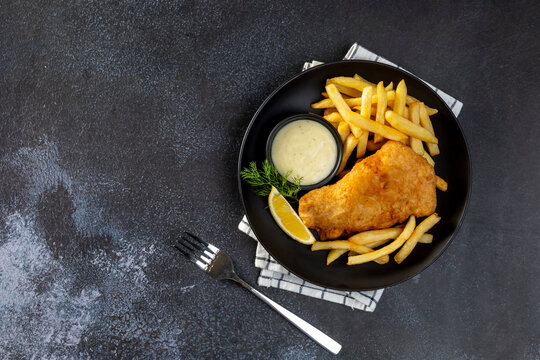 Fish and Chips: Classic British meal of crispy battered fish served with golden fries and tartar sauce. - Powered by Adobe