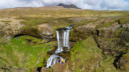Majestic waterfall cascading down rocky cliffs in Icelands stunning landscape