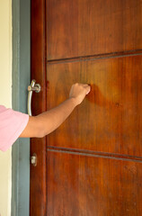 Someone's hand was knocking on the door of the house