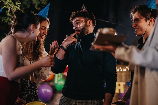 A joyful gathering of friends celebrating a birthday in a festive backyard setup during the evening, featuring laughter, decorations, and birthday hats, embodying friendship and celebration.