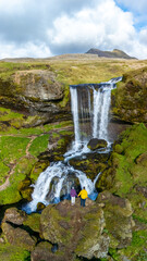 Majestic waterfall in Iceland with couple enjoying natures beauty