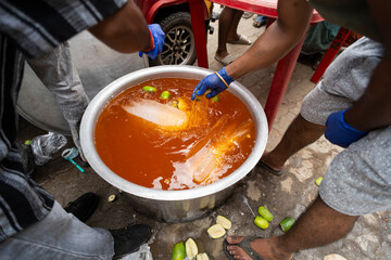 Volunteers makes refreshment drinks to offer devotees