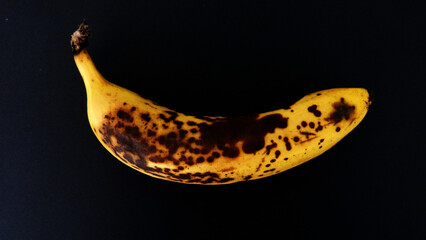 Banane trop mûre sur fond noir