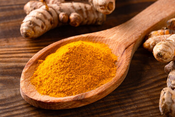 Turmeric with its magnificent orange color on a vintage wooden background	