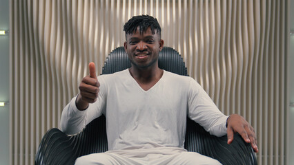 African American ethnic man male guy showing thumb up like gesture agree approve satisfied positive sign happy recommend innovation internet gaming in futuristic studio recommendation futurism room