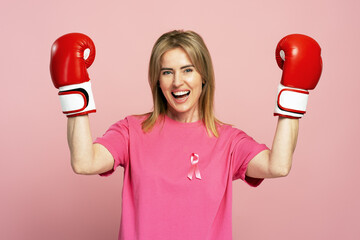 Woman wearing boxing gloves and pink ribbon celebrating breast cancer awareness