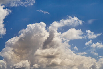Obraz premium White cumulus clouds in yellow sunlight under gusts of wind in the sky, close-up, view among clouds high in the sky, cloud texture in close-up.