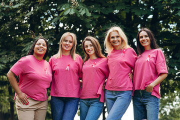 Diverse women embracing and supporting breast cancer awareness
