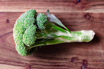 A fresh head of broccoli on a wood cutting board