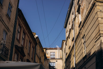 Narrow old European street with buildings and blue sky, charming travel scene.