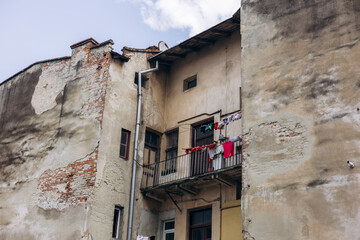 Colorful clothes drying on the balcony of an old weathered building.