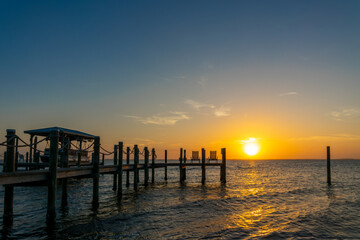 Fototapeta premium Boat pier and palm trees, sunset landscape on the Banana River in Cocoa Beach, Florida