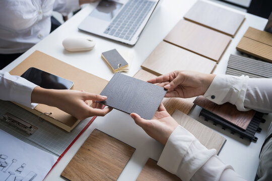 Interior designer presenting eco friendly wooden material samples for sustainable home decor