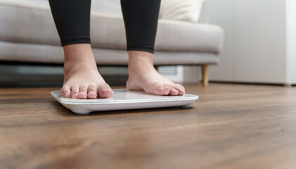 Fat diet and scale feet standing on electronic scales for weight control. Measurement instrument in...