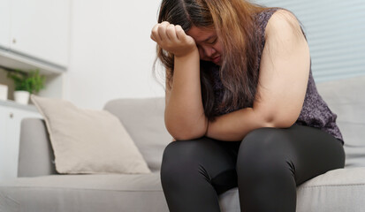 Obraz premium Sad Overweight plus size woman thinking about problems on sofa upset girl feeling lonely and sad from bad relationship or Depressed woman disorder mental health
