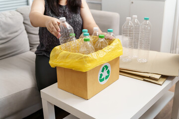 Home recycle eco green zero concept Woman throwing empty plastic bottle in recycling bin with...