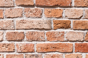 Red brick wall texture. Rustic masonry background with cement joints. Aged construction detail with natural imperfections. Traditional building material for architectural and design projects.