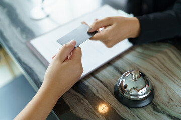Hotel receptionist in uniforms Concierge giving the key doing check-in at the hotel desk in lobby...