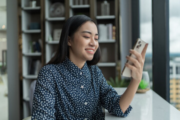 Asian woman using smartphone mobile addict spending time checking news social media cell telephone...