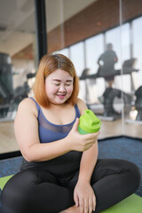 Obese asian woman dieting Weight loss in sportswear drink healthy drink. Sporty asian fat female...