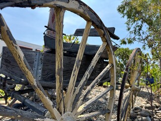 A close-up detail of a weathered, rustic wagon wheel in San Marcos, California, highlighting its...