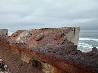 A close-up shot focusing on the extreme rust build-up on a guardrail near the ocean in Carlsbad,...