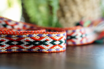 Traditional Lithuanian woven national band with colorful ethnic patterns, displayed on a wooden...