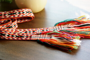 Traditional Lithuanian woven national band with colorful ethnic patterns, displayed on a wooden...