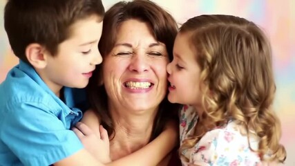 Loving mother hugging her son and daughter while they smile and kiss her on the cheek celebrating mother day - Lifestyles