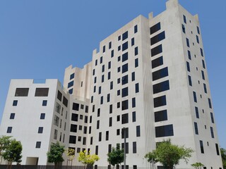 White Color Commercial Residential Building Complex with Black Color Windows And Blue Sky Background. Highrise Skyscraper Building Exterior Outdoor Full View. G+10 floor Tallest Skyline With PentHouse