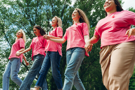 Women holding hands and walking together for breast cancer awareness
