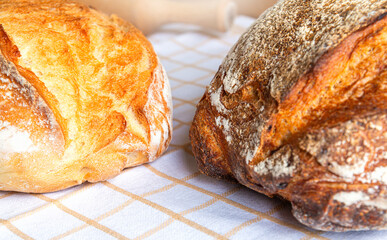 Freshly baked artisan bread resting on a cloth in a cozy kitchen setting during the afternoon
