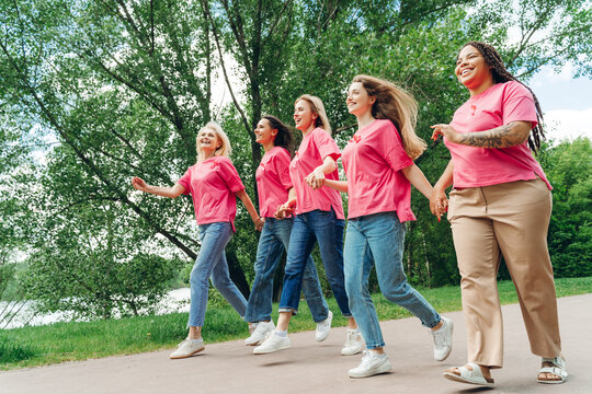 Interracial group of women running for breast cancer awareness in park