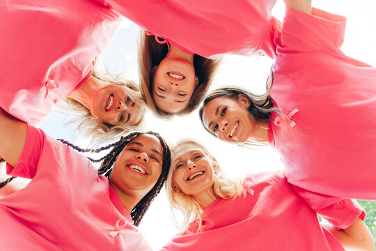 Smiling women wearing pink ribbon supporting breast cancer awareness