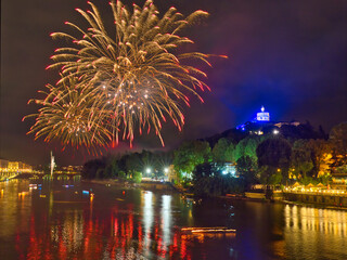 Fireworks over the Po River in Turin, Italy, during the San Giovanni celebration, with illuminated...