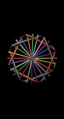 Abstract arrangement of colorful sticks and curved ribbons against a dark background, forming a radial pattern.