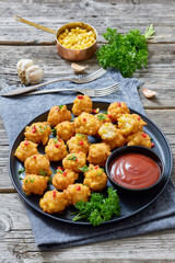 corn nuggets on a plate with tomato sauce