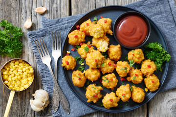corn nuggets on a plate with tomato sauce