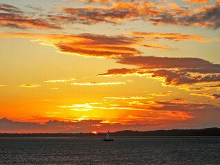 A distant dhow sailing against the golden sunset of the southern coast of Mozambique