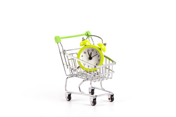 Alarm clock in miniature supermarket shopping trolley on white background