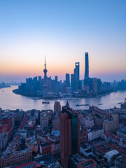 Obraz premium Aerial view of Shanghai skyline with winding river at sunrise.