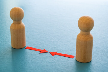 Concept of conflict I war between people or groups. Wooden figures gathered in two groups facing each other.
