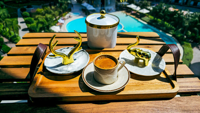 Turkish coffee served with golden decor on a wooden tray