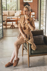 beautiful stylish girl dressed in safari boho style against the backdrop of a stylish colonial...